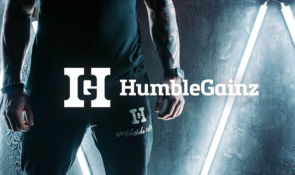 Humble Gainz Athletic Wear Display | Idea Stream Marketing Close-up of a person wearing black Humble Gainz joggers and a sleeveless top under neon lights.