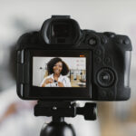 Person recording short-form video content with a camera for social media marketing campaign.