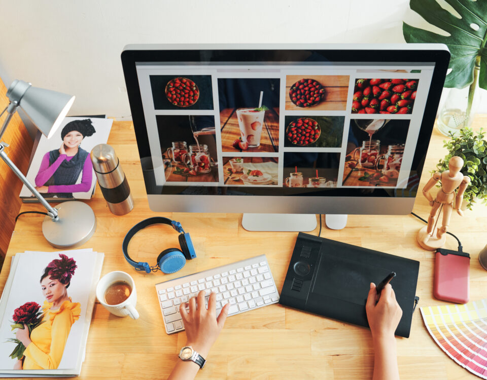 Designer working on modern website layout showcasing digital images and creative branding on desktop computer