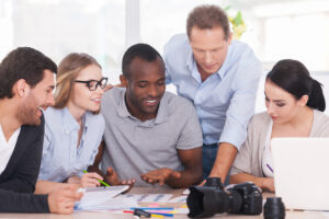 Marketing team brainstorming around a table with laptops, sticky notes, and a content calendar in a modern office.