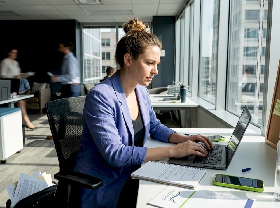 Marketer working at window-side office desk