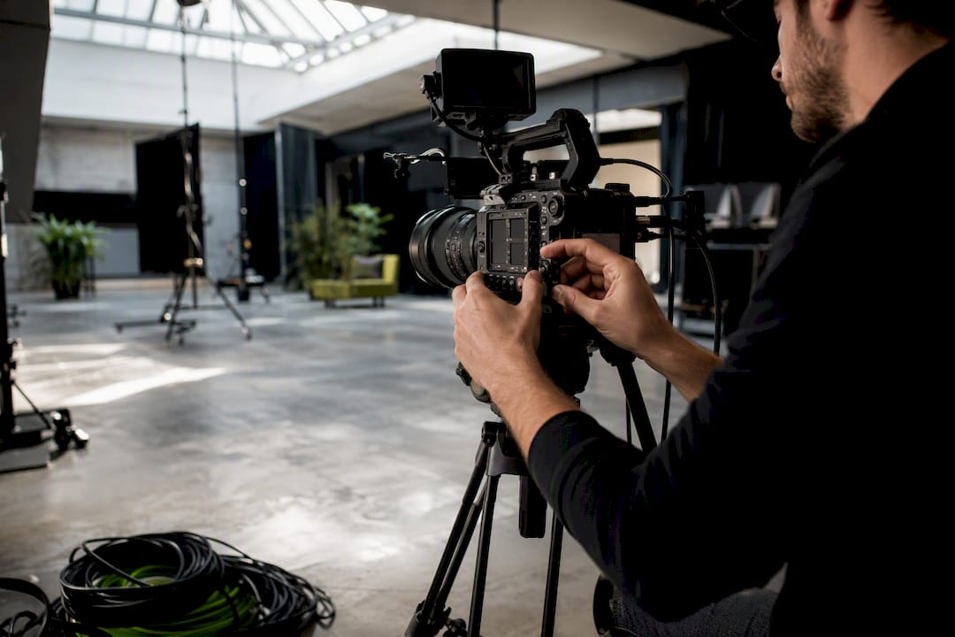 Hands adjusting professional video camera lens