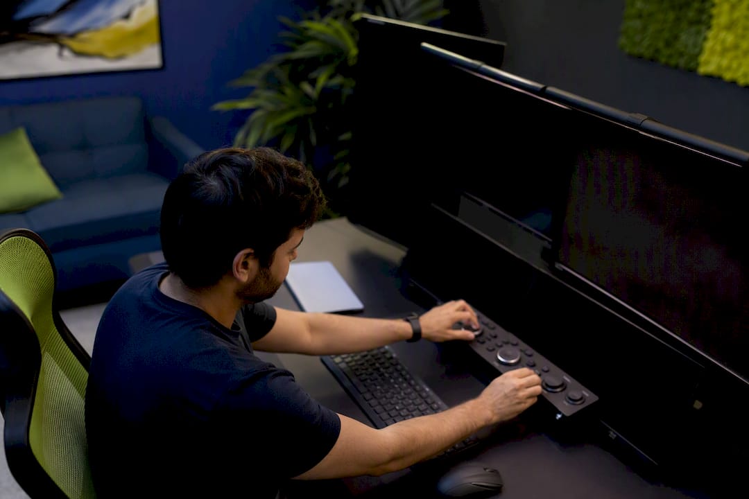 A person adjusting controls on a digital campaign workspace with multiple monitors.